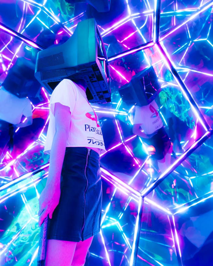 pexels-photo-18161127 A conceptual art piece featuring a woman with a vintage TV for a head, surrounded by neon lights and mirrors.